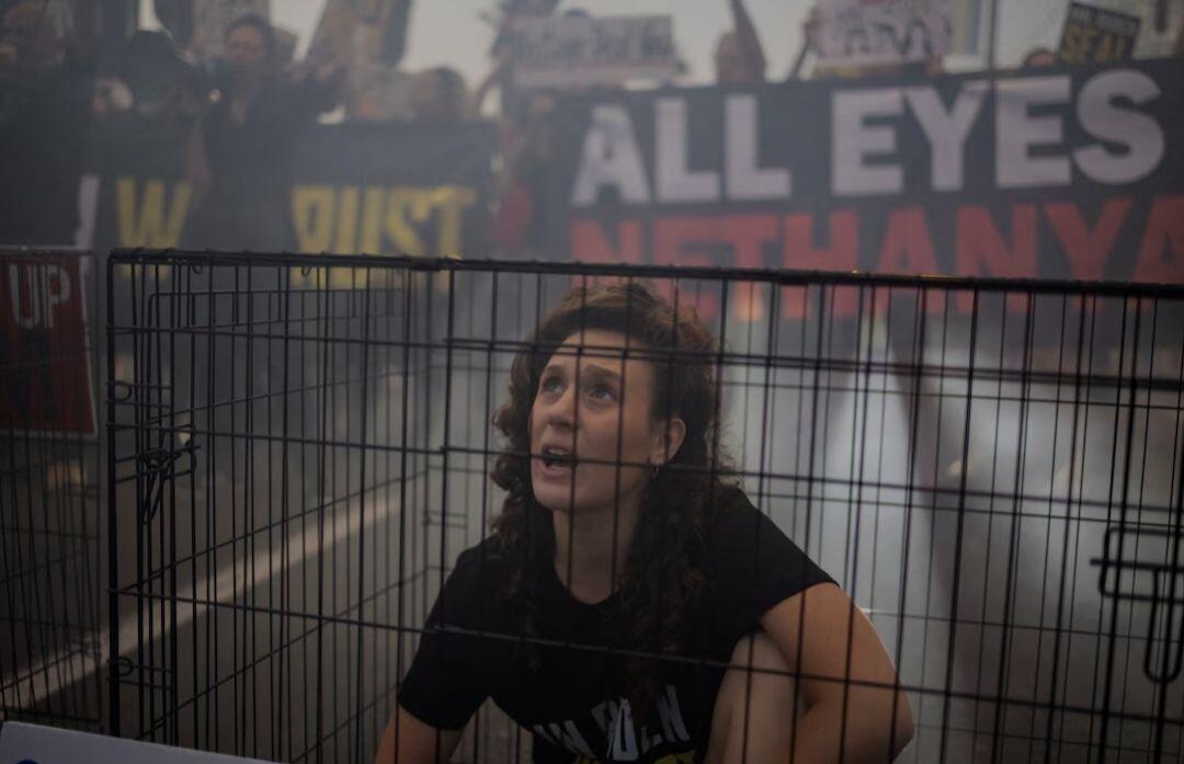 A woman sits in a cage…