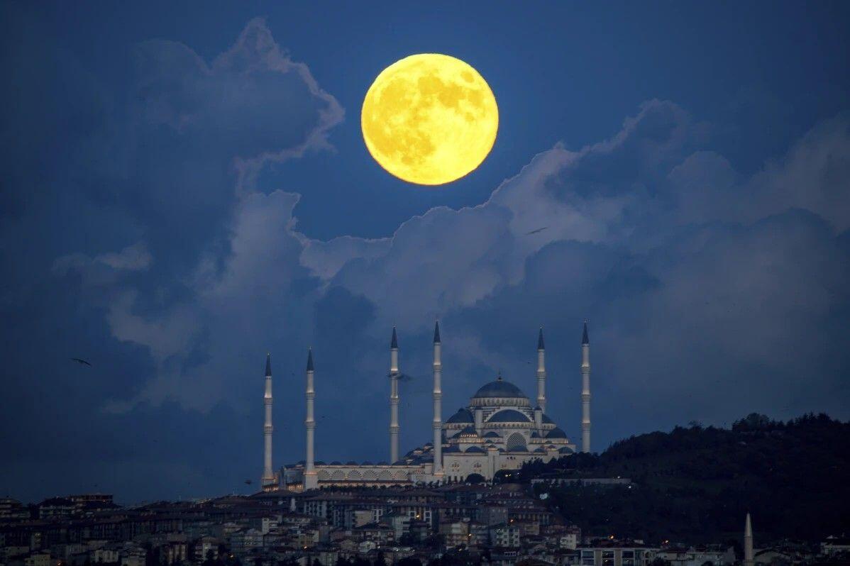 A supermoon rises behind the Camlica…