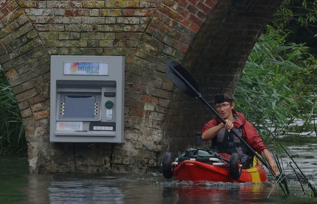 A kayaker paddles past an art…