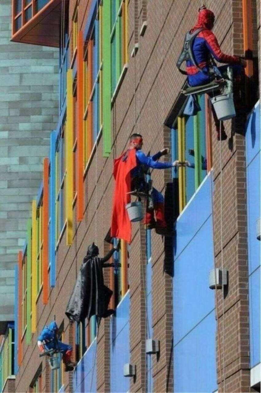 Superheroes washing windows in a children'…