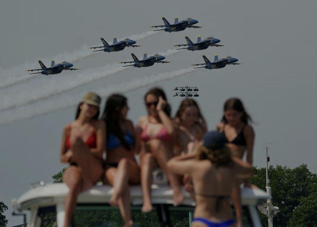 Women atop a boat take a…