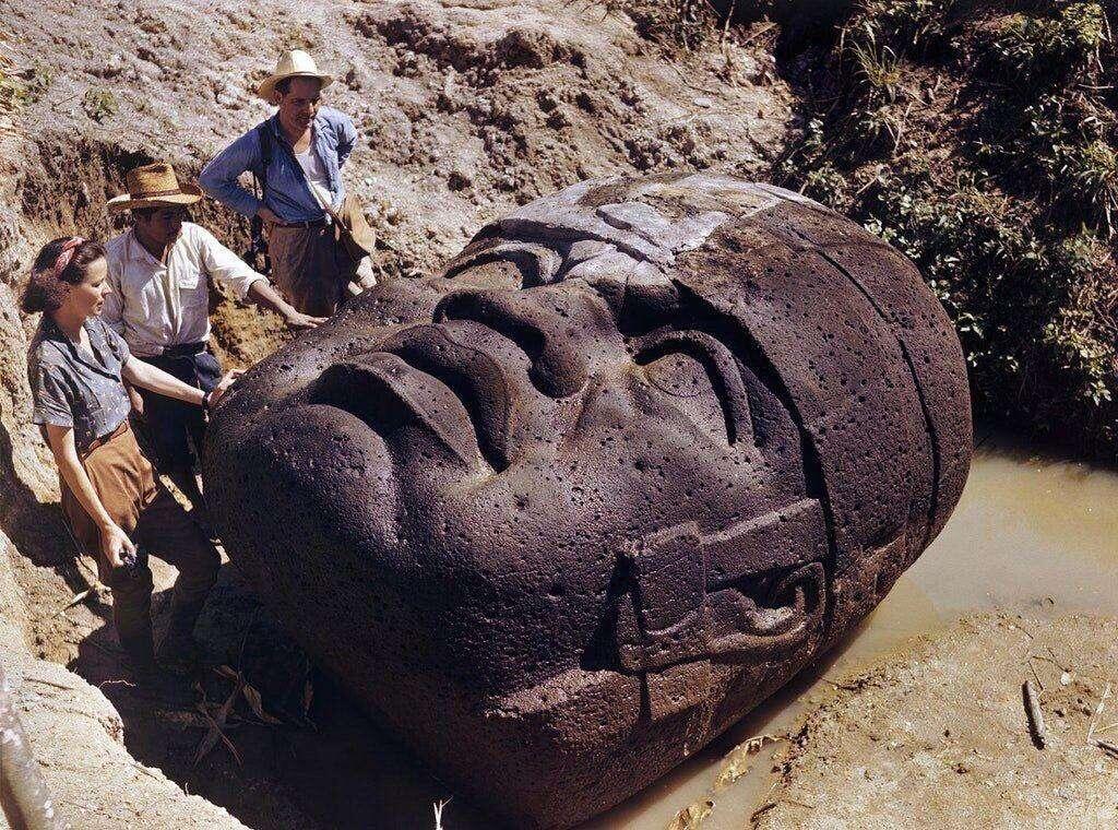 Archaeologists study an Olmec stone head…