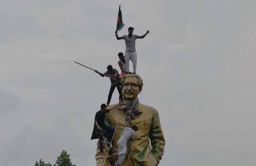 People climb the statue of Sheikh…