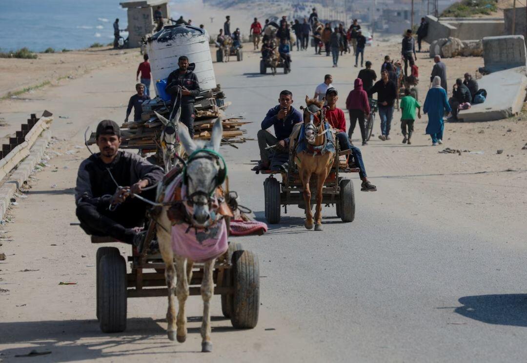 People ride animal-drawn carts as…