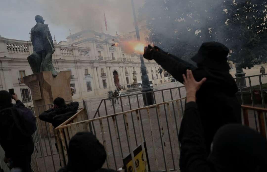 Demonstrators protest outside La Moneda government…